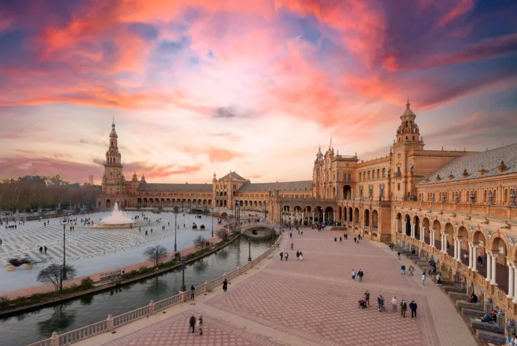 Coucher de soleil spectaculaire sur la Plaza de España à Séville, Espagne, illuminant l'architecture emblématique et les couleurs vibrantes de la place